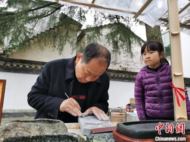 资料图：国家级非遗——徽州砖雕传承人向游客展示雕刻技艺。 张强 摄