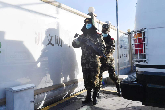 1月28日，马建东上岗执勤前，战友为他整理装备。新京报记者 李木易 摄