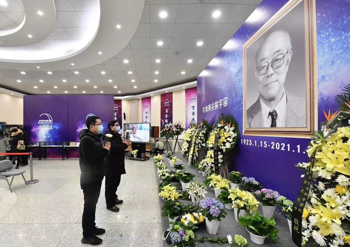 悼念者手持白花，在王绶琯院士遗像前肃立。摄影/新京报记者 吴宁