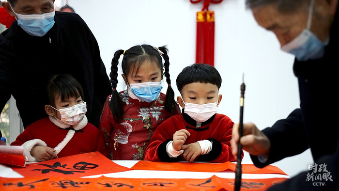  △金元社区居民活动室内，孩子们观摩书法写作。（总台央视记者王哈男拍摄）