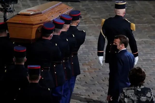 在一场国家纪念活动中，马克龙注视着帕蒂的灵柩 图源：路透社