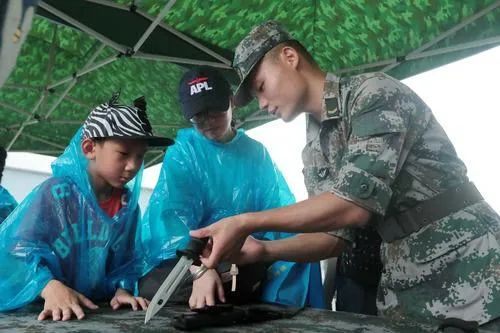 ▲资料图片：解放军驻港部队战士向市民讲解轻武器知识。（新华社）