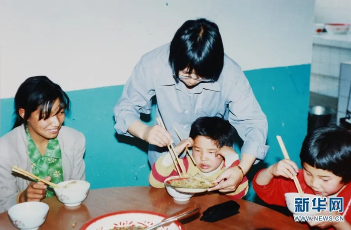 ▲2002年，张桂梅在华坪县儿童福利院照顾孩子们吃饭（资料图）。新华网发（华坪县融媒体中心 供图）