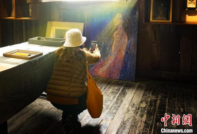 图为游客观赏记录重庆三毛故居内的三毛画像。 陈鑫 摄