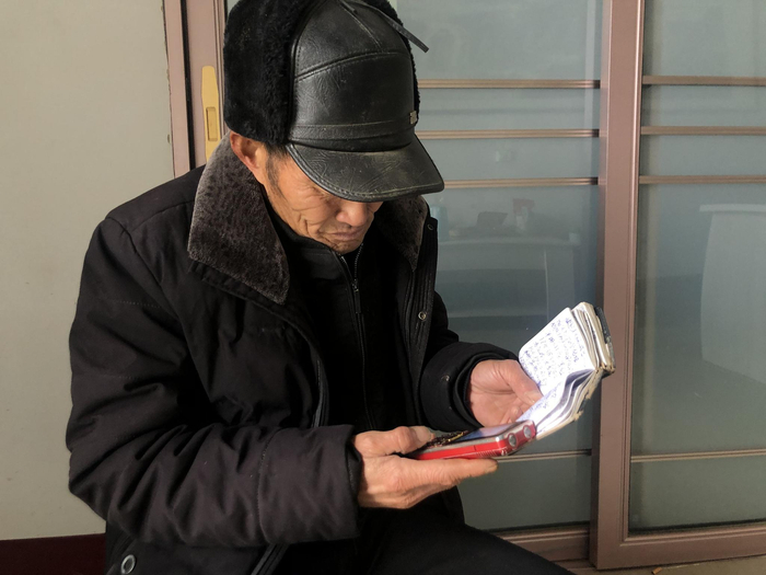 媒人吕有聚正在联系未婚男青年。新京报记者 杜寒三 摄