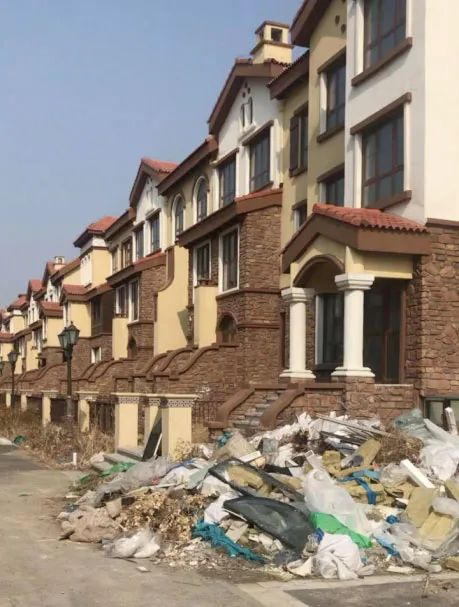 众美青城清溪花苑项目二期b段基主体基本完工的别墅门口杂草丛生，堆满了建筑垃圾 李叶/摄