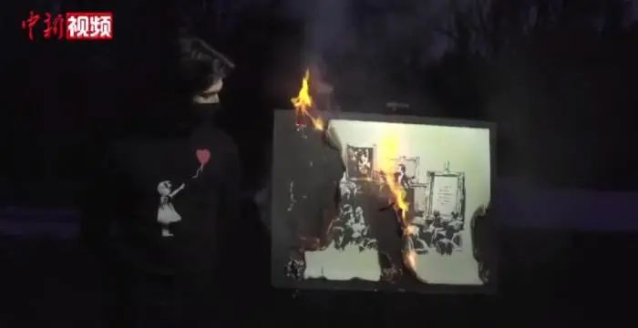 　　一群艺术爱好者烧掉了世界著名街头艺术家班克西的作品《傻子》，随后将其电子版本所有权以超4倍价格卖出。视频截图