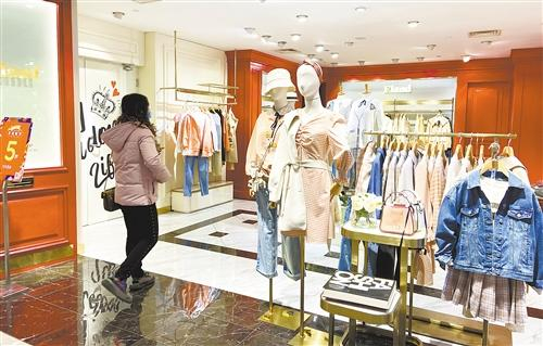 优化门店体验，拓展线上销售，成为服装实体店转型的方向。图为顾客在北京汉光百货商场选购服装。本报记者 刘 瑾摄