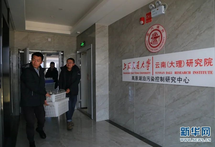 图为研究人员将采样需要的仪器从实验室里搬出来，运到船上。（新华网 丁凝/摄）