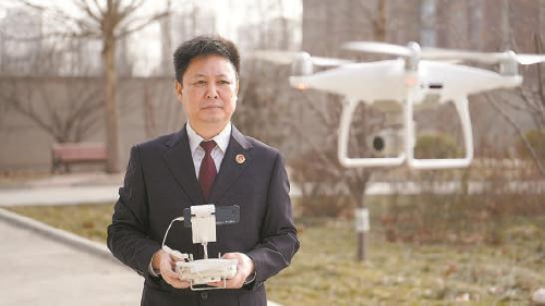 王文杰驾驶无人机对一块非法占地进行测量取证 