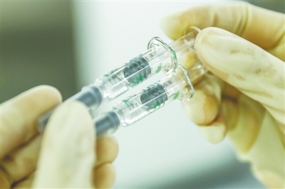 　　2020年12月25日，工作人员在国药集团中国生物北京生物制品研究所的新冠病毒灭活疫苗分包装车间内检查产品包装质量。 新华社 图