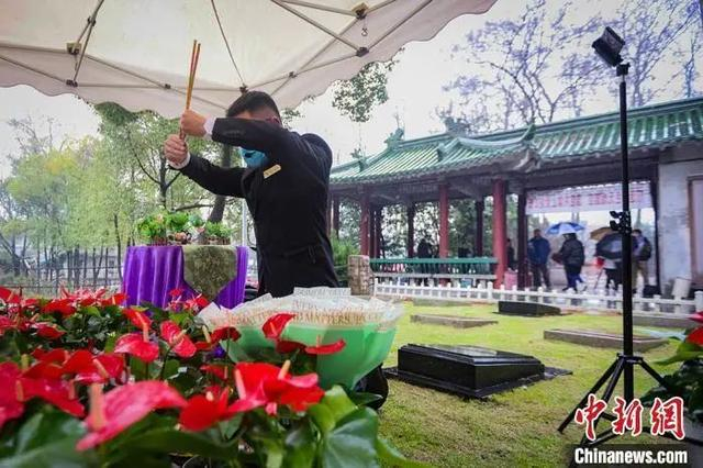 资料图：3月11日，清明节临近，南京开通5G“云”祭扫寄哀思。墓地前，雨花台功德园工作人员走上前，依次献花敬香，宣读悼词。 泱波 摄