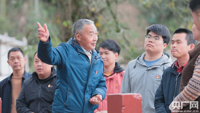 老党员郭爱林在讲述红军桥的党史故事