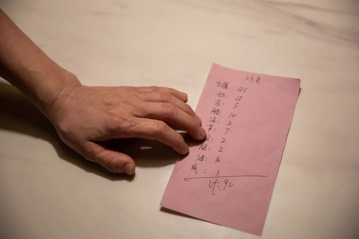 ▲作为“班长”，女浴区每日的搓澡单量和项目数，罗永芹都会统计在纸上。新京报记者 李凯祥 摄