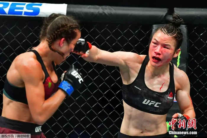 张伟丽在UFC248站女子草量级世界冠军卫冕战上，在五个回合里以点胜击败波兰选手乔安娜，成功卫冕。图为张伟丽（右）在卫冕战比赛中。