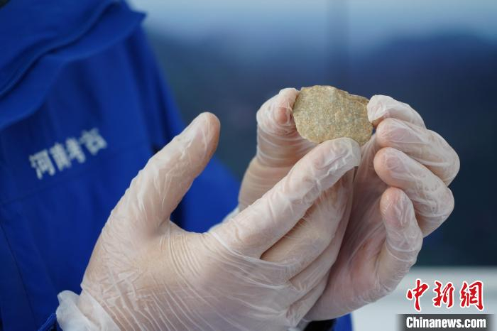 图为考古人员展示出土的打制器 李超庆 摄