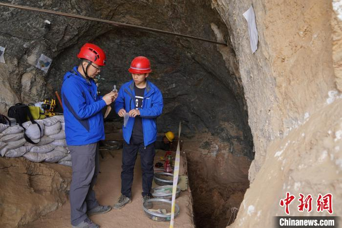 图为考古人员查看出土的碳样 李超庆 摄