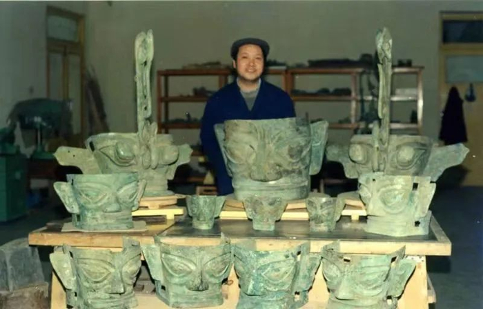 ▲杨晓邬和修复的青铜头像。受访者供图