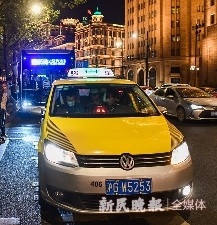 图说：执法人员查处出租车拒载行为