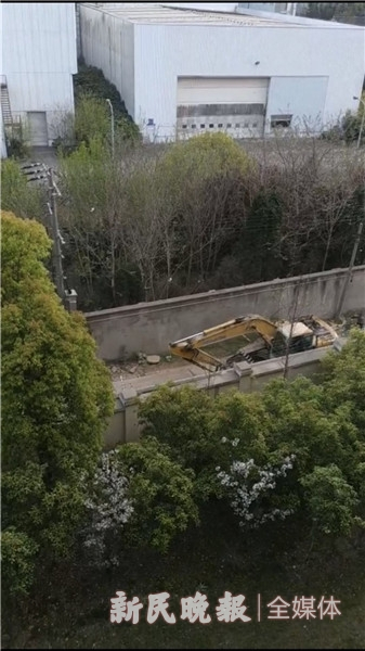 图说：小路紧邻居民住宅，不时有挖掘机等驶过