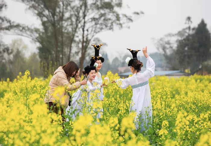 游客在油菜花园里“翩翩起舞”（央广网发 忠县融媒体中心供图）