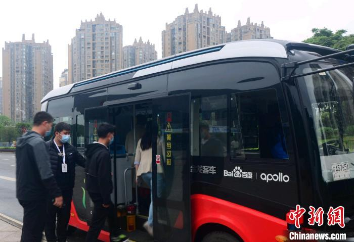 图为自动驾驶公交车安全员指引乘客上车。　王利华 　摄