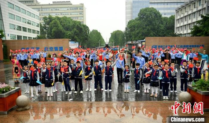 青年员工与孩子们在航空工业成飞大门前《歌唱祖国》。　刘忠俊 摄
