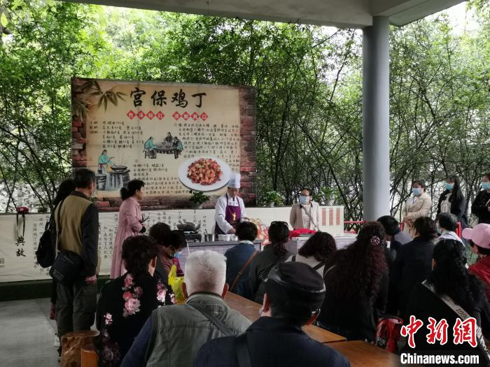 游客观看川菜宫保鸡丁制作过程。　单鹏 摄