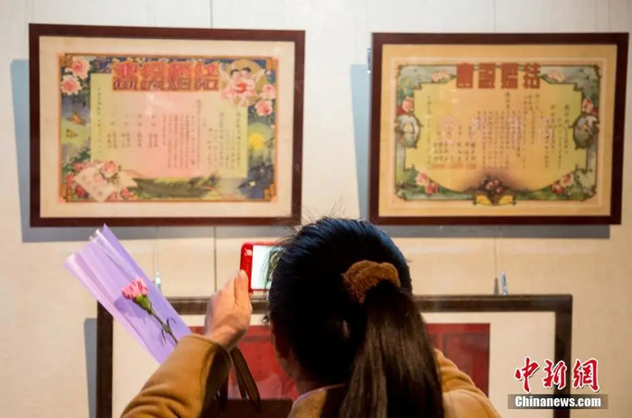 图为各个历史阶段的结婚证书、情书吸引参观者目光。中新社记者 张畅 摄