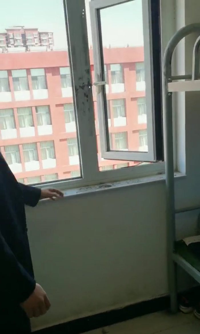 学校工作人员向张长发介绍事发窗口。受访者供图