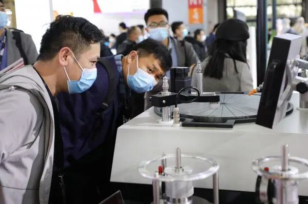 ▲2021中国国际半导体展3月17日在沪开幕，参观者近距离观看一台进行作业演示的晶圆研磨抛光设备展品。（方喆 摄）