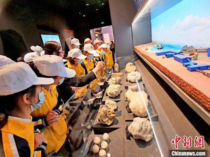 图为青少年正在听讲解员讲述矿物资源相关知识。　祁增蓓 摄