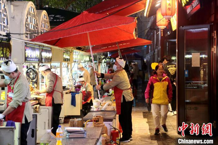 图为商家支起雨伞。　张远 摄