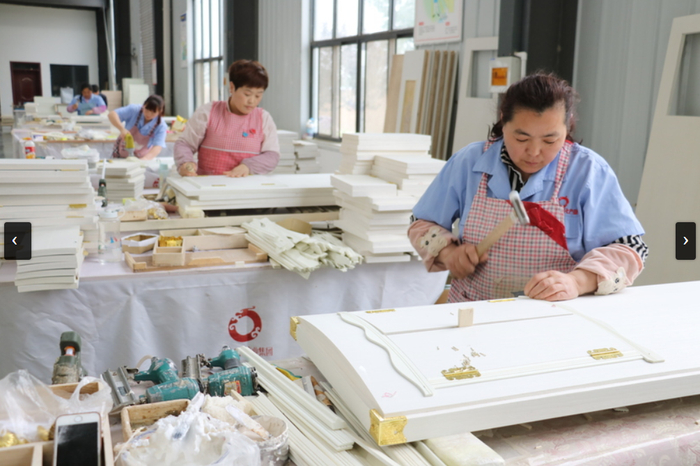 图源：新华社新闻，制作员工骨灰盒盖和小窗户的员工（摄于2019年5月8日）。