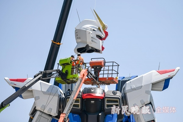 图说：实物大自由高达立像展开头部安装作业  新民晚报记者 陈梦泽 摄（下同）