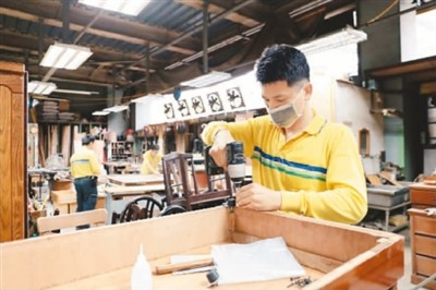台北市环保局木工厂内，师傅正在耐心修复废旧木柜组件。许宸瑄摄