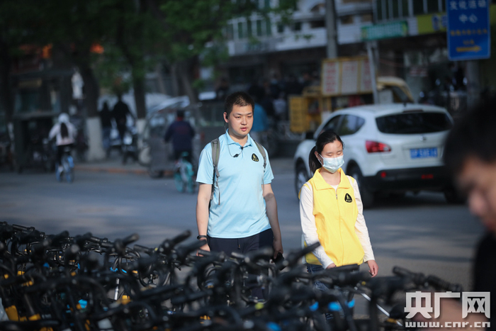 余素一在指导学员如何前往地铁站（央广网记者 韩靖 摄）