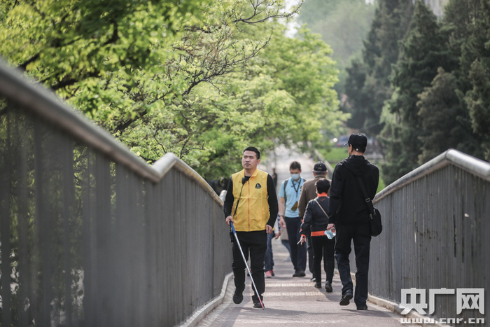 为了更好地听声音，杨青风在学员前方行走（央广网记者 韩靖 摄）