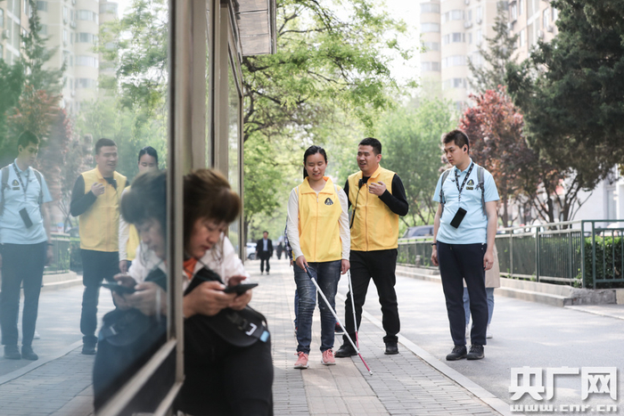 杨青风与助教余素一在指导学员如何前往公交站（央广网记者 韩靖 摄）