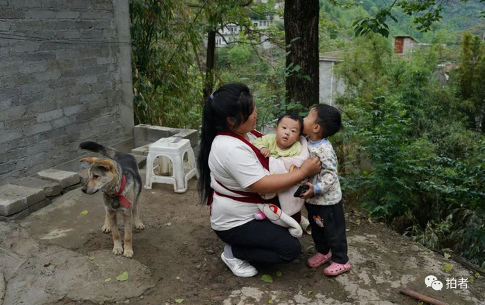 ▲从医院回到家后，罗进春2岁的儿子上前亲吻几天没见的弟弟。