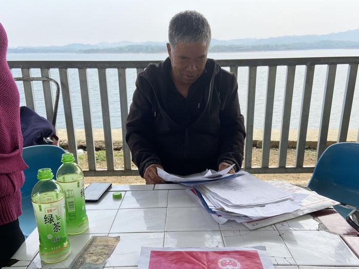 杜国政翻看多年前与乡里签订的护林协议。新京报记者 李雨凝 摄