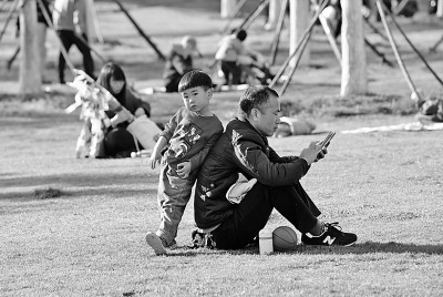 安徽合肥市绿轴公园，市民带着孩子在草地上休闲。新华社发