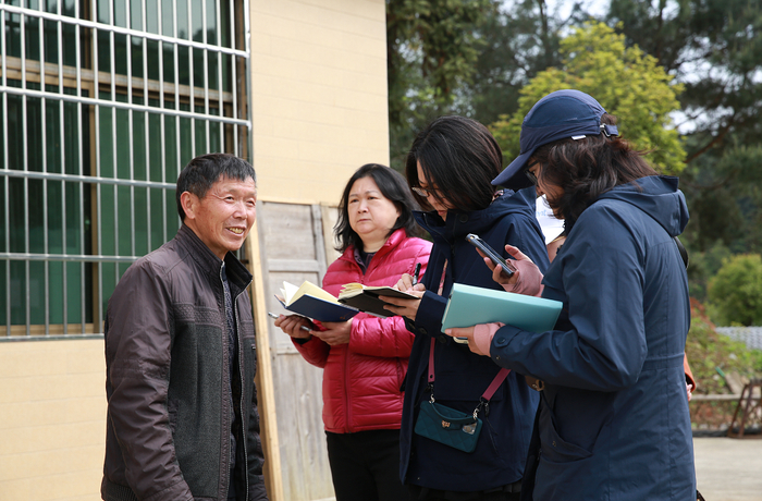 ▲江西省九江市修水县庙岭乡上坪村民库区迁岀村民余光金接受记者（左三）采访