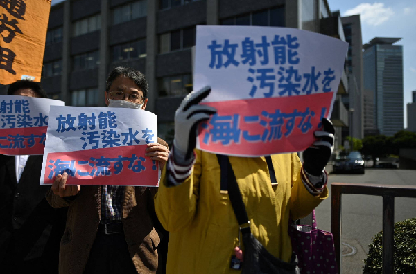 图说：首相官邸外，日本民众打出反对排放核废水的标语。 GJ图