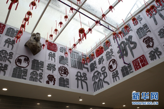 那马服务区主体综合楼一层“那字墙”上，展示“那”字在汉字和古壮字中的各种不同写法。新华网聂晨静 摄