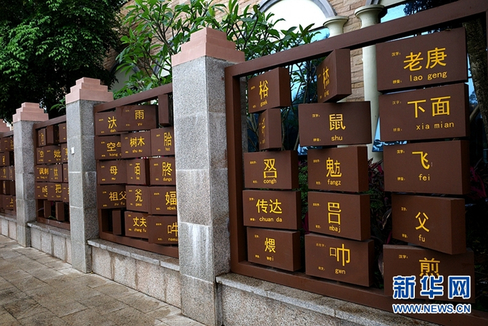 那马服务区的广场一角，用木格印刷的方式创意展示汉、壮两种语言文化，其中一面印有汉字和拼音，另一面印有相同字义的古壮字和壮文。新华网聂晨静 摄
