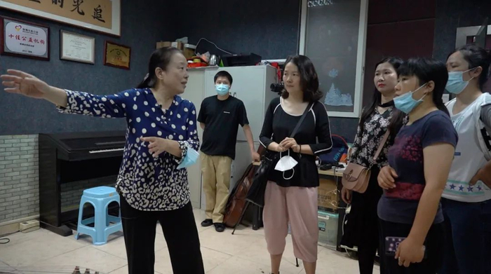 孙莉莉与家长们商量排练事宜。新京报记者 王伟哲 摄