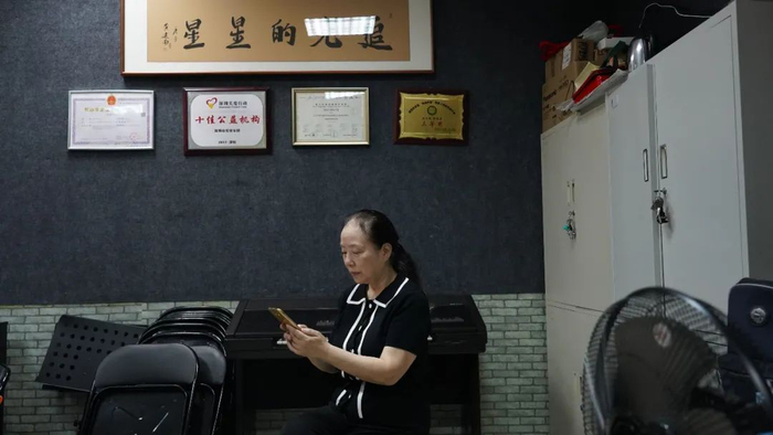 排练室里，孙莉莉在手机上处理乐团事务。新京报记者 王伟哲 摄