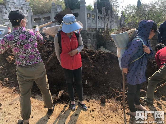 妇女正在背运泥土（记者 周益帆 摄）