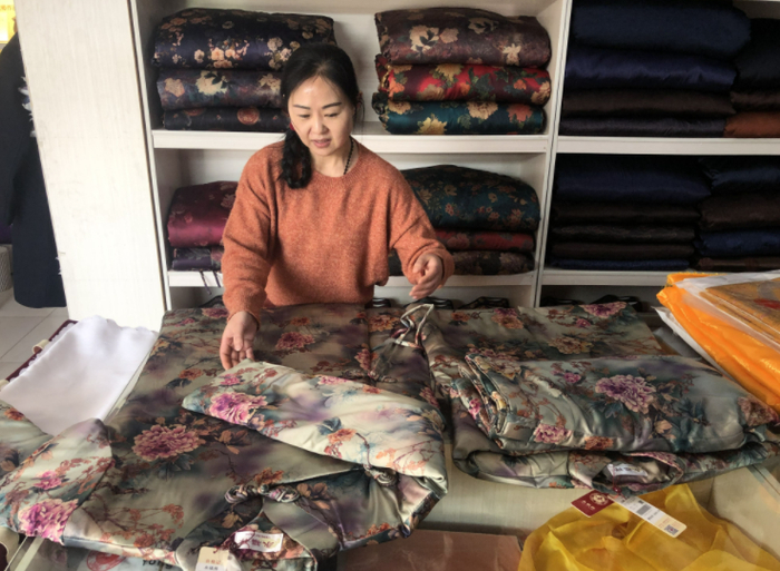 荣姐正在整理店里的寿衣。新京报记者 张静姝 摄